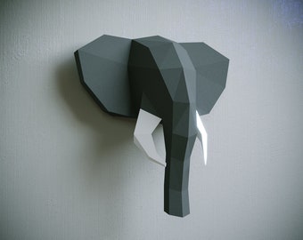 May include: A black and white origami elephant head wall decor. The elephant's head is made of paper and has a 3D effect. The elephant's tusks are white.