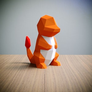 May include: Orange and white origami paper model of a Pokemon character, Charmeleon. The model is standing on a wooden surface.