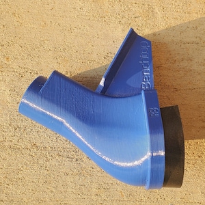 May include: A blue plastic 3D printed object with a black base. The object has a curved shape and a label that reads "Benchtop".