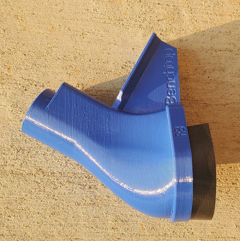 May include: A blue plastic 3D printed object with a black base. The object has a curved shape and a label that reads "Benchtop".