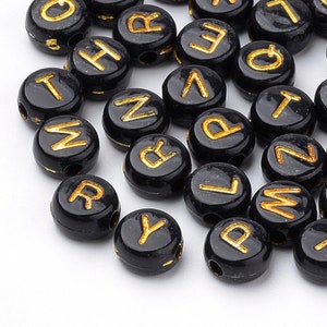 300 black Alphabet beads with gold writing 7mm