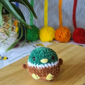 Small crochet mallard duck plush displayed on desk as cute decoration