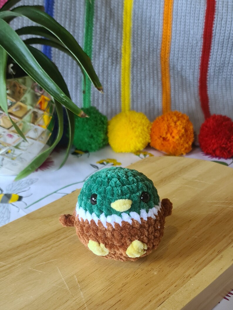 Small crochet mallard duck plush displayed on desk as cute decoration