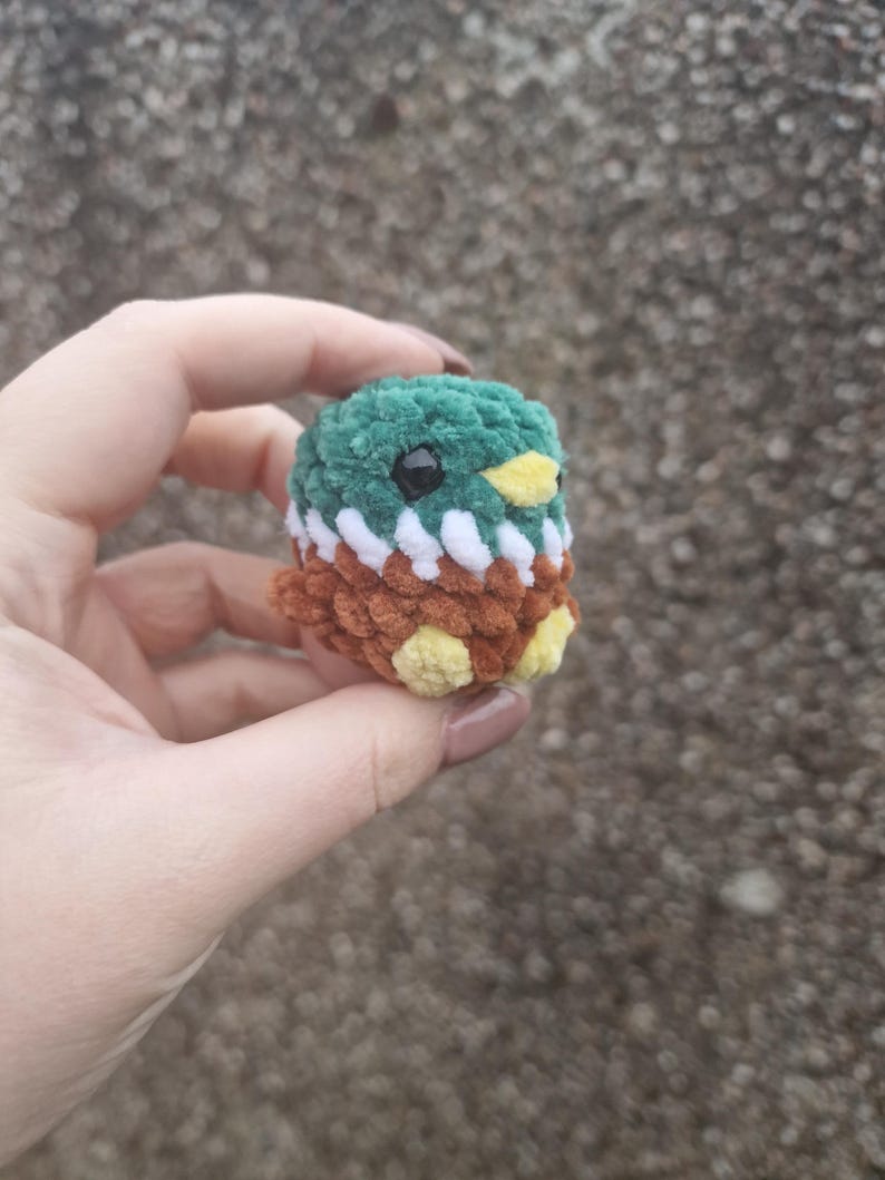 Side view of tiny handmade crochet mallard duck plush showing wings