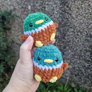 Two handmade crochet mallard duck plush toys held in hand