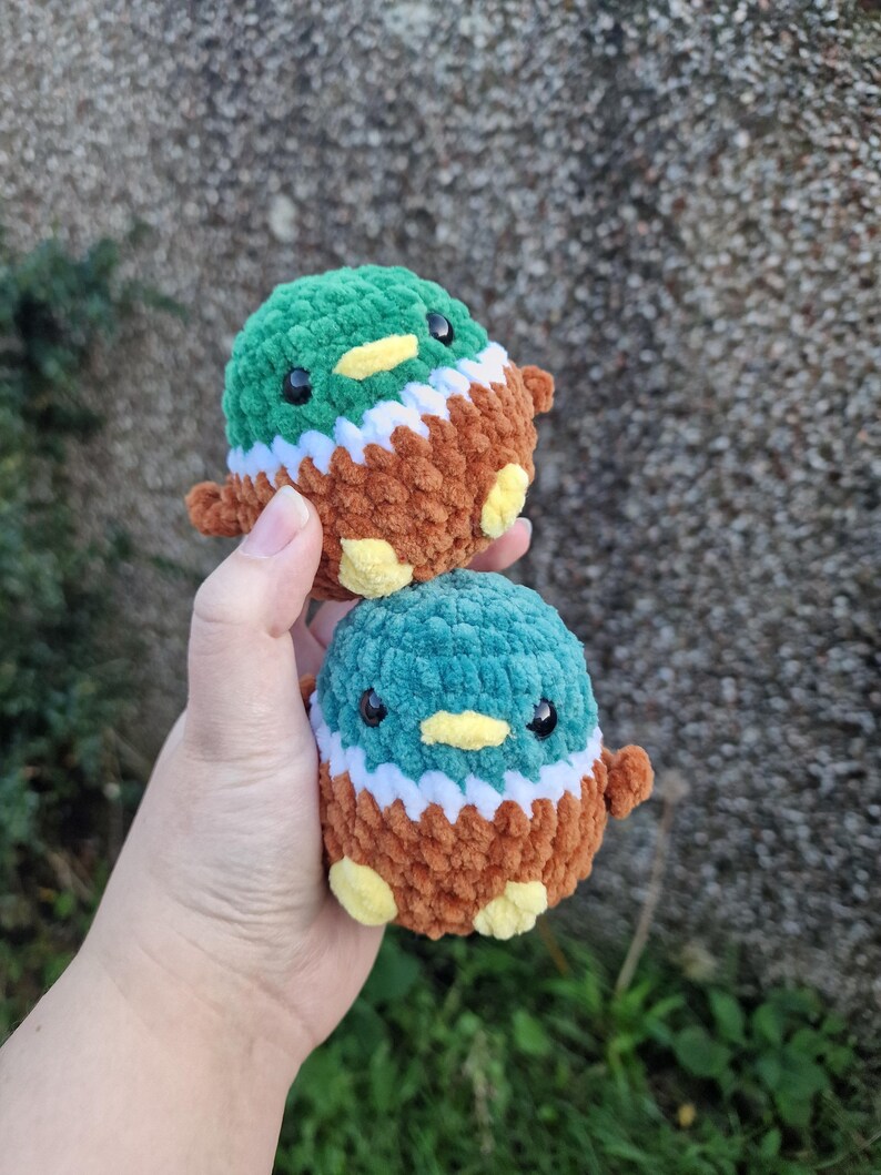 Two handmade crochet mallard duck plush toys held in hand