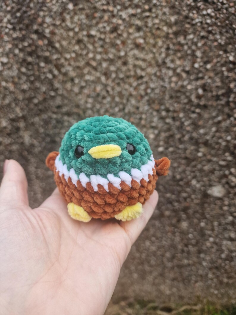 Tiny mallard duck plush sitting in a hand showing the small 7cm size