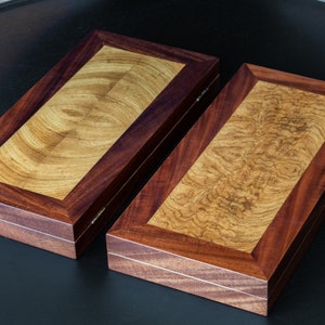 May include: Two wooden boxes with a dark brown wood frame and a light brown wood interior. The boxes have a natural wood grain pattern.