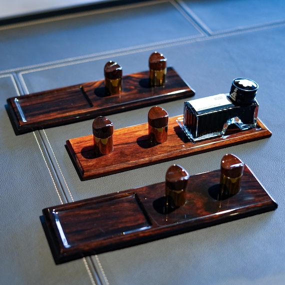 A single-pen display cradle hand-turned from genuine ebony — the kind of desk object that makes fountain pen people stop and stare.