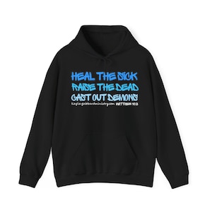 May include: A black hooded sweatshirt featuring blue graffiti-style text that reads HEAL THE SICK, RAISE THE DEAD, CAST OUT DEMONS. Below the text, the white print displays kaylagabbardministry.com and the reference MATTHEW 10.8.