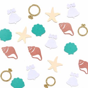 Peut inclure: Diverses découpes de papier de différentes formes et couleurs. Comprend des cloches blanches avec des nœuds, des anneaux dorés à paillettes, des étoiles de mer beiges, des formes de coquilles Saint-Jacques turquoise et des coquillages corail. Idéal pour l'artisanat ou les décorations de fête.