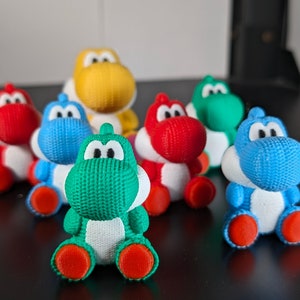 May include: A set of seven small, plush dinosaur toys in various colors, including red, blue, green, and yellow. The dinosaurs are all in a sitting position and have a cartoonish appearance.
