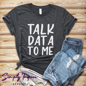 Könnte beinhalten: Ein dunkelgraues T-Shirt mit dem Text "TALK DATA TO ME" in weißen Buchstaben.