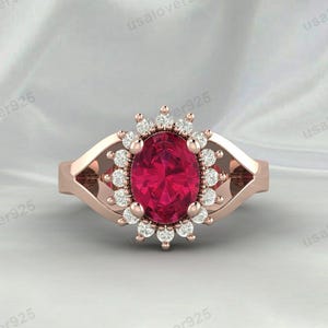 Op de afbeelding: Een ring van roségoud met een grote ovale robijn omringd door een halo van kleinere diamanten.