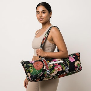 Puede incluir: Bolsa negra para esterilla de yoga con un colorido estampado floral. La bolsa tiene cierre de cremallera y una correa para el hombro con un diseño floral a juego. La bolsa mide aproximadamente 71 cm de largo.
