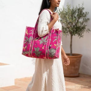 Peut inclure: Un sac fourre-tout rose vif avec un imprimé tropical représentant des palmiers, des zèbres et des toucans. Le sac a une texture matelassée et une forme rectangulaire avec des poignées robustes. Le sac est porté à l'épaule.