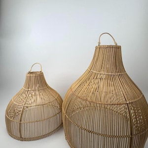 May include: Two woven rattan pendant light fixtures. The larger fixture is approximately 24 inches tall and 18 inches wide, while the smaller one is about 18 inches tall and 14 inches wide. Both have a teardrop shape and a handle at the top.