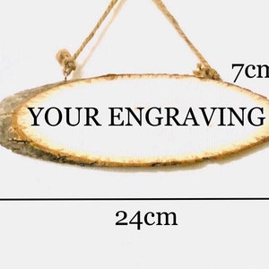 以下が含まれることがあります： 7cm x 24cm のサイズで、素朴な仕上げの楕円形の木製看板です。看板は空白で、「YOUR ENGRAVING」というテキストを彫刻する準備ができています。