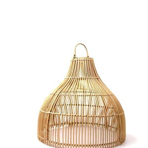 May include: A natural woven rattan lampshade with a bell shape and a handle at the top. The lampshade is made of vertical and horizontal rattan strips, creating an open, airy design. The color is a light tan.
