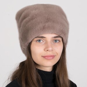 May include: A brown fur hat with a wide brim. The hat is made of soft, fluffy fur and has a simple, classic design.