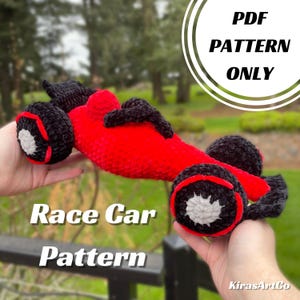 May include: A handmade red crochet race car with black wheels and accents. The wheels have a red trim and a white center. The image includes the text "Race Car Pattern" and "PDF Pattern Only".
