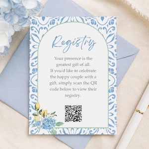 Könnte beinhalten: Eine rechteckige Registrierungskarte mit einem blau-weißen, fliesenartigen Rand, einem zentralen Bogen und blauen sowie gelben Blumenakzenten. Der Text lautet: Registry, Your presence is the greatest gift of all. If you'd like to celebrate the happy couple with a gift, simply scan the QR code below to view their registry.
