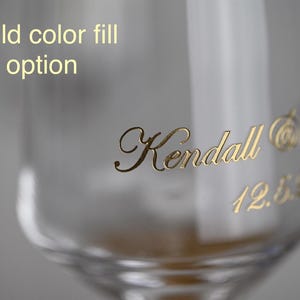 Puede incluir: Primer plano de un vaso transparente con letras doradas. El texto dice "Kendall" en cursiva, junto con texto dorado adicional y la fecha "12.5.62". Las palabras "Gold color fill option" est&aacute;n en la parte superior.