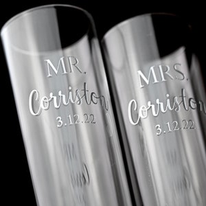 May include: Two clear glass champagne flutes with the text "MR. Corriston 3.12.22" and "MRS. Corriston 3.12.22" etched on them.