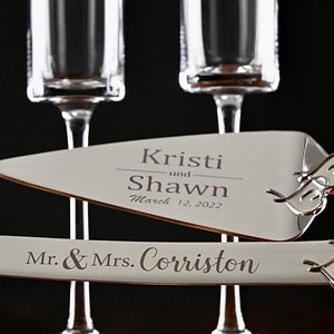 May include: Two champagne flutes and a cake server with the text "Kristi and Shawn March 12, 2022" and "Mr. & Mrs. Corriston" engraved on them.