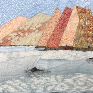 Könnte beinhalten: Ein gequiltetes Kunstwerk, das eine Landschaft mit einer Reihe von bunten, geometrischen Bergen vor einem blauen Himmel mit weißen Punkten darstellt. Die Berge bestehen aus Stoffresten in Rot-, Orange-, Gelb- und Brauntönen. Im Vordergrund ist ein Gewässer mit einer dunklen Form in der Mitte zu sehen.