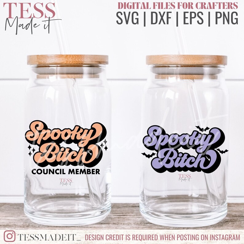 May include: Two clear glass jars with lids and straws. The jars have a design on the front that says "Spooky Bitch" in a retro font. One jar has an orange design and the other has a purple design. The orange jar also has the text "Council Member" below the design.