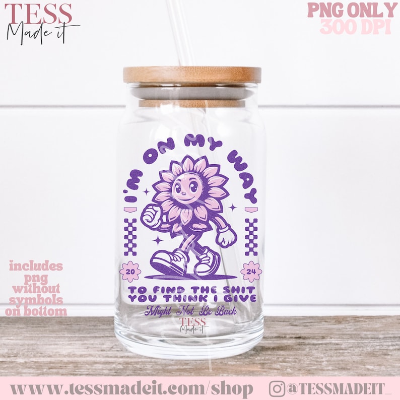 May include: Purple and pink graphic design on a clear glass jar with a wooden lid. The design features a cartoon sunflower with a smiling face walking and the text "I'm on my way" and "To find the shit you think I give. Might not be back".