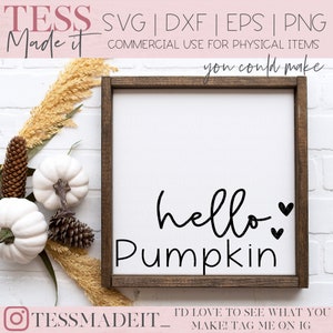May include: A white wooden sign with a brown frame, featuring the text "hello pumpkin" in black cursive lettering with two small hearts.