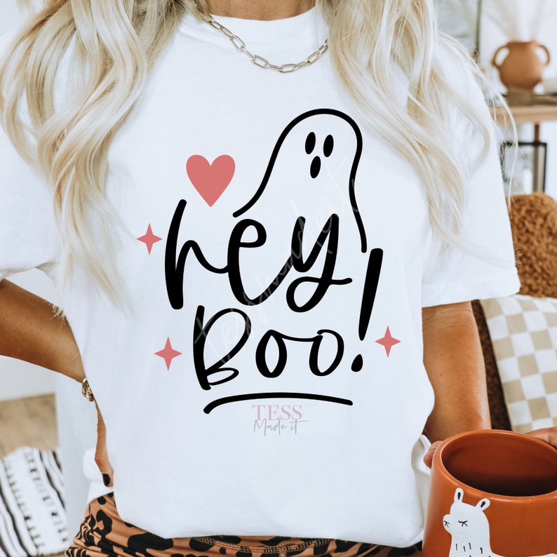 May include: White t-shirt with a black ghost and the text "hey! boo!" in black with a pink heart and stars. The text "TESS Made it" is in pink at the bottom of the shirt.