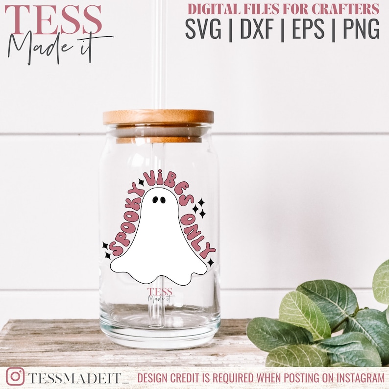May include: A clear glass tumbler with a wooden lid and a straw. The tumbler has a pink and white design with a ghost and the text "Spooky Vibes Only".