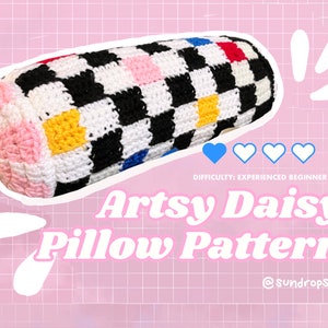 Könnte beinhalten: Ein Häkelkissenmuster mit einem karierten Design in Schwarz, Weiß, Rosa, Gelb, Blau und Rot. Das Kissen ist zylinderförmig und hat an einem Ende ein Gänseblümchen-Design. Der Text "Artsy Daisy Pillow Pattern" ist in einer Retro-Schriftart geschrieben. Der Schwierigkeitsgrad ist mit "Erfahrener Anfänger" angegeben.