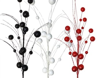 May include: Three decorative floral sprays featuring thin, branching stems adorned with spherical ornaments. One spray is black, one is white, and one is red. Each sphere has a textured, glittery finish, and the stems extend outward.