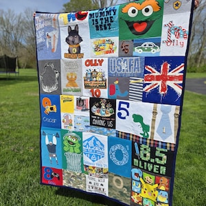 May include: A memory quilt constructed from various colorful t-shirt panels featuring diverse graphic prints, including cartoon characters like Oscar the Grouch, Pikachu, and Among Us, alongside text such as My Mummy Is The Best and Otis.