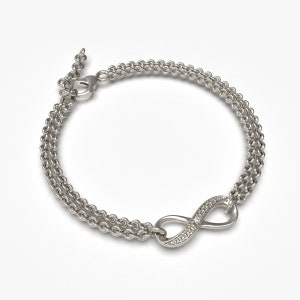 May include: A silver infinity charm bracelet with a double chain and small clear stones set in the infinity symbol.
