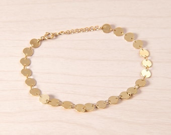 May include: A gold chain necklace with a series of round, flat, gold discs.