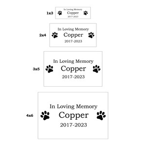 以下が含まれることがあります： 「In Loving Memory Copper 2017-2023」というテキストと、2 つの足跡が刻まれたペットの追悼用プレートが 4 つ、それぞれ異なるサイズで表示されています。