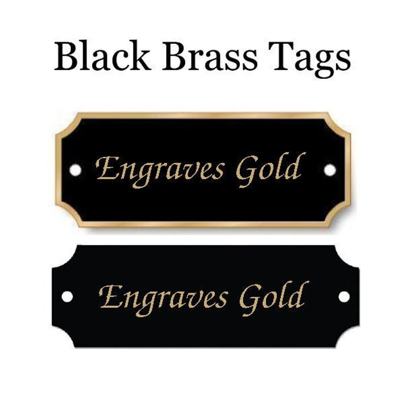 K&ouml;nnte beinhalten: Zwei schwarze Messing-Etiketten mit goldener Beschriftung "Engraves Gold".