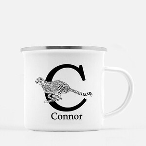 Puede incluir: Taza de camping de esmalte blanco con una letra C negra y una ilustración de guepardo. El nombre Connor está impreso debajo de la letra.