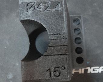 May include: A black 3D-printed object with a curved opening and a series of small holes. The text "Ø42.4" and "15°" are visible on the surface. The object appears to be a custom-made part.