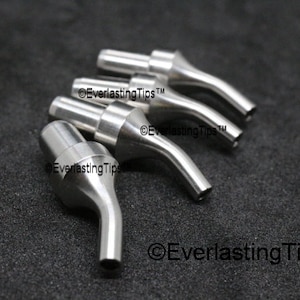 Puede incluir: Cuatro puntas de soldadura de metal plateado con cuello curvo y una pequeña abertura en el extremo. Las puntas están dispuestas en fila sobre una superficie negra. El texto "©EverlastingTips™" es visible en la superficie.