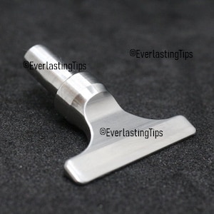 May include: A silver metal T-shaped tool with a round handle. The tool is designed for use with a variety of crafts and hobbies.