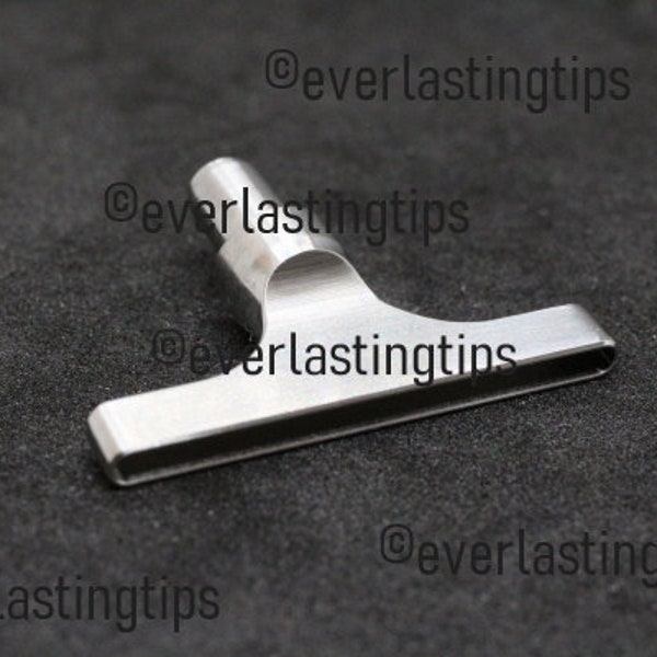 May include: A stainless steel T-shaped tool with a cylindrical top and a rectangular handle. The tool is designed with a curved section connecting the top and handle, and is set against a dark background.