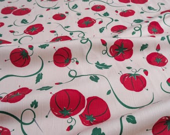 May include: Cream-colored fabric with a repeating pattern of red tomatoes, green vines, and leaves. The tomatoes have green star-shaped tops. The vines and leaves are a dark green color. The fabric has a slightly wrinkled texture.