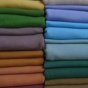 May include: A set of three ceramic mugs with a speckled, matte finish. The mugs are in shades of cream, light gray, and dark gray. Each mug has a simple, minimalist design, perfect for coffee or tea.