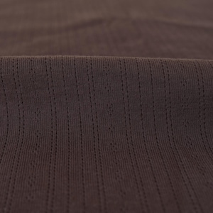 May include: Close-up of a brown ribbed fabric with a subtle texture.